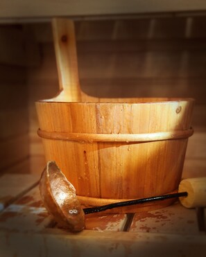 A wooden bucket with a handle and a metal scoop.