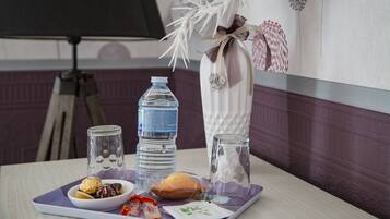 Ein Tisch mit einer Wasserflasche, einem Glas, einer kleinen Schale mit Essen und einem dekorativen Gegenstand.