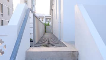 Una escalera de hormigón estrecha que conduce a una zona de techo plano con una rejilla metálica.