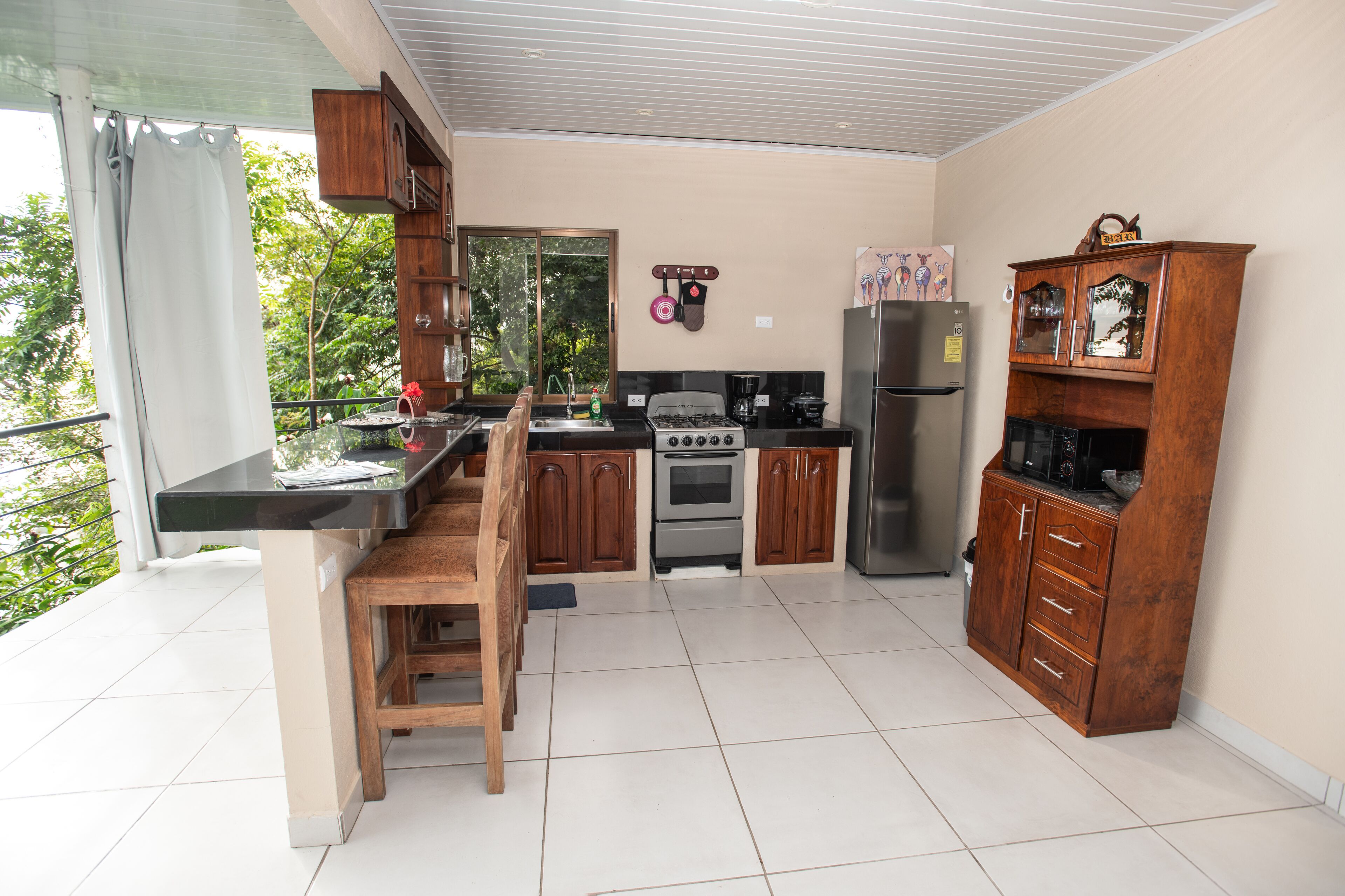 A modern kitchen with wooden cabinets, a gas stove, and a refrigerator.