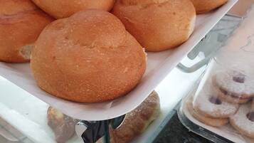 A tray of freshly baked rolls on a glass counter.