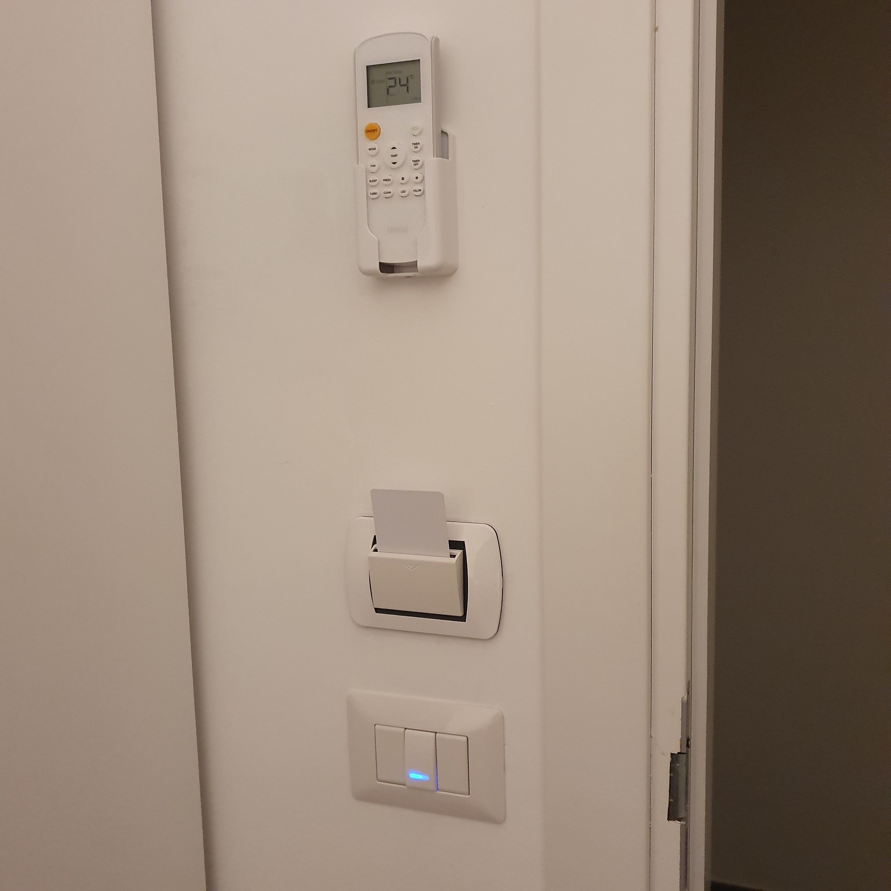 A wall-mounted control panel with a digital display, a card reader, and a light switch.