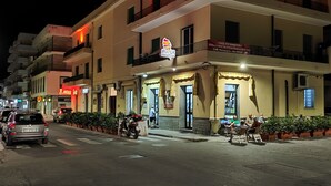 A multi-story building with a restaurant on the ground floor, featuring outdoor seating and a visible sign. - Fantasia B&B (Reggio Calabria)