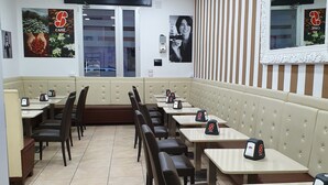 A cafe with booths and tables, a striped wall, and a mirror. - Fantasia B&B (Reggio Calabria)
