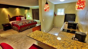 Une chambre d’hôtel comprenant un lit, un bureau, une kitchenette et une salle de bain.