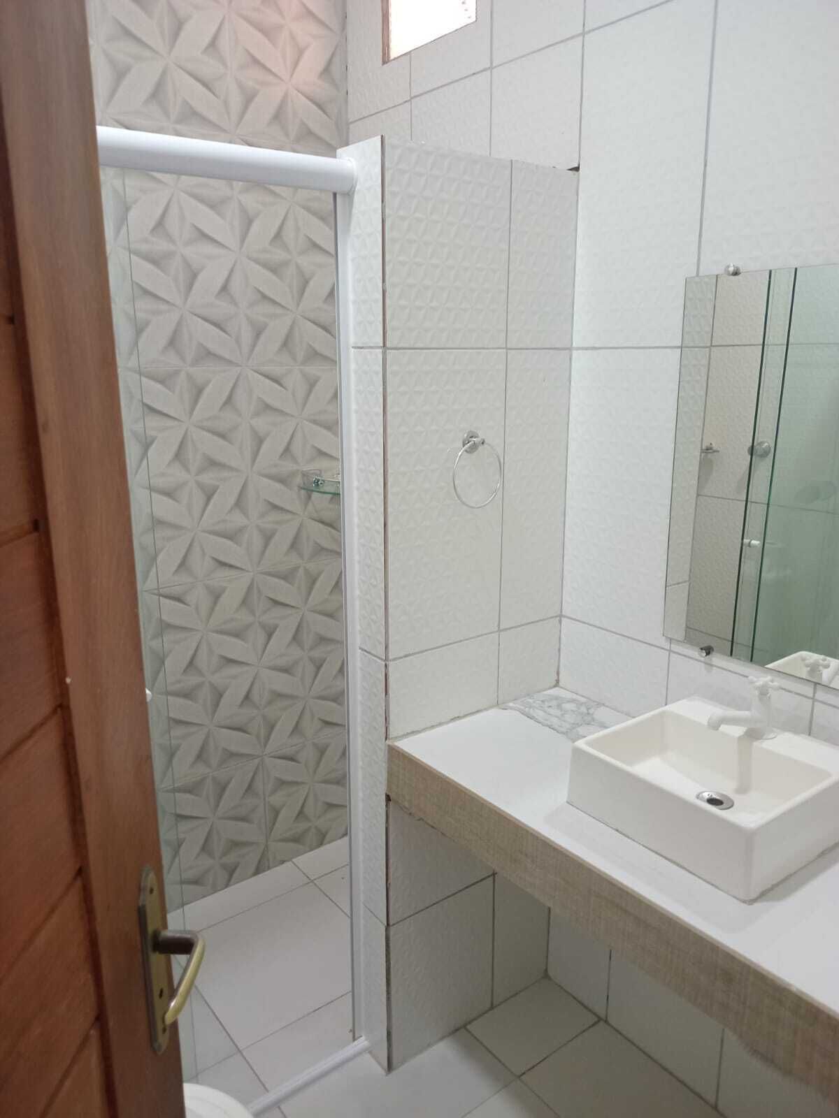 Un baño con ducha, lavamanos y espejo.