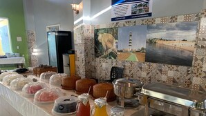 Un'area buffet con pietanze coperte, un angolo bevande e un frigorifero.