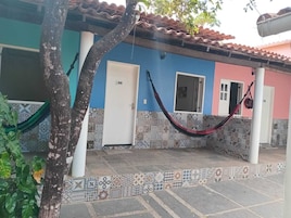 Un edificio con un patio empedrado, una hamaca y una puerta con la etiqueta '109'.