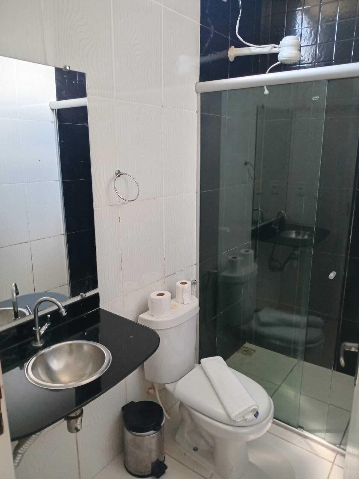 A bathroom with a sink, toilet, and glass-enclosed shower.