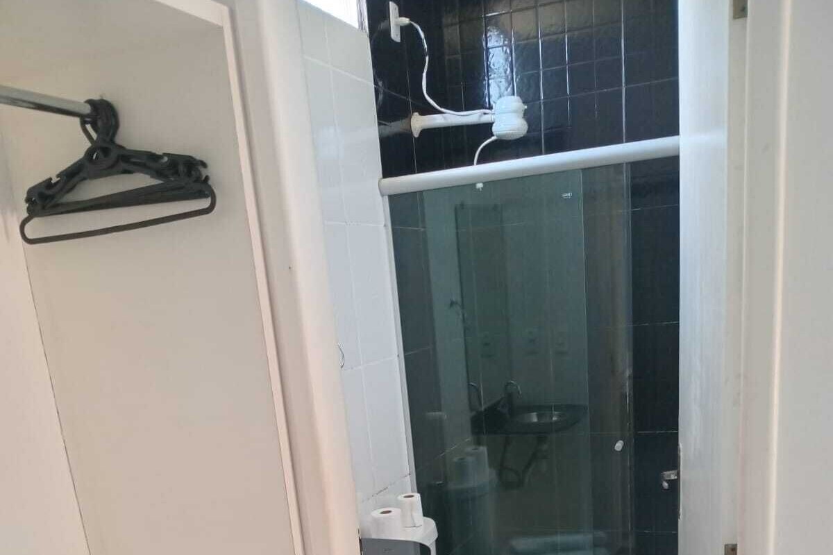 A small, compact bathroom with a toilet, a sink, and a shower enclosure.