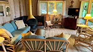 A cozy living room with a sofa, chairs, a fireplace, and a television. -  Private Waterfront Setting on Lake Michigan (Shelby)