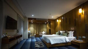 A hotel room with a large bed, a desk, a chair, and a TV mounted on the wall. - CITADEL Hotel By Vinnca (Hyderabad)
