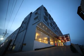 A modern building with a glass facade and a staircase leading to the entrance. - CITADEL Hotel By Vinnca (Hyderabad)