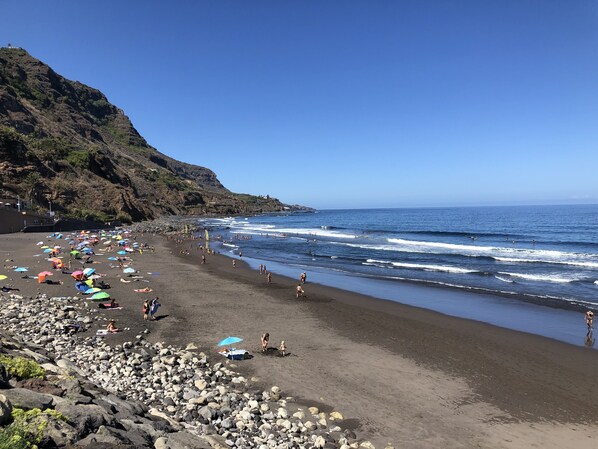 Playa en los alrededores y playa de arena negra