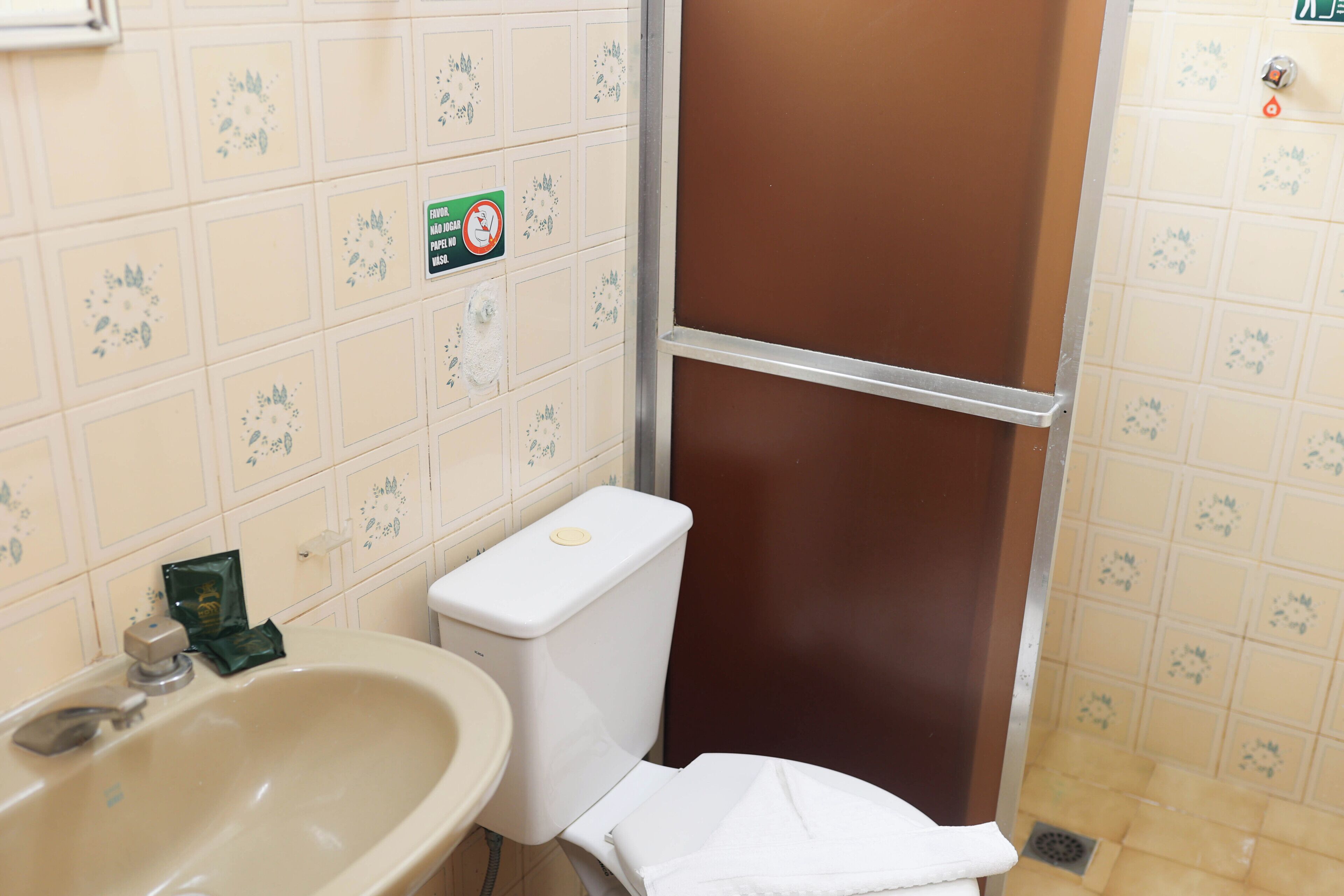 A bathroom with a sink, toilet, and shower area.
