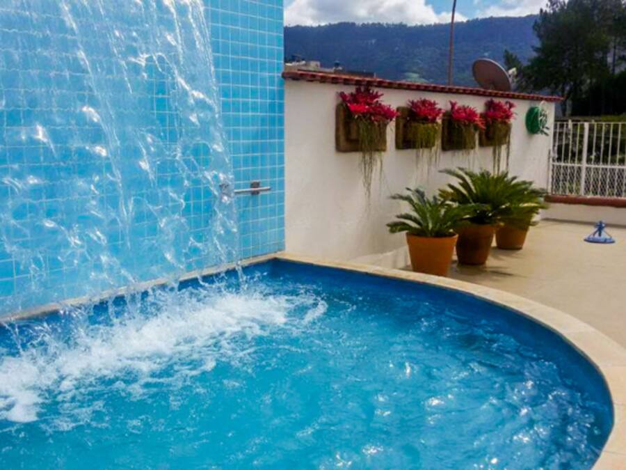 Een buitenzwembad, parasols bij het zwembad en ligstoelen