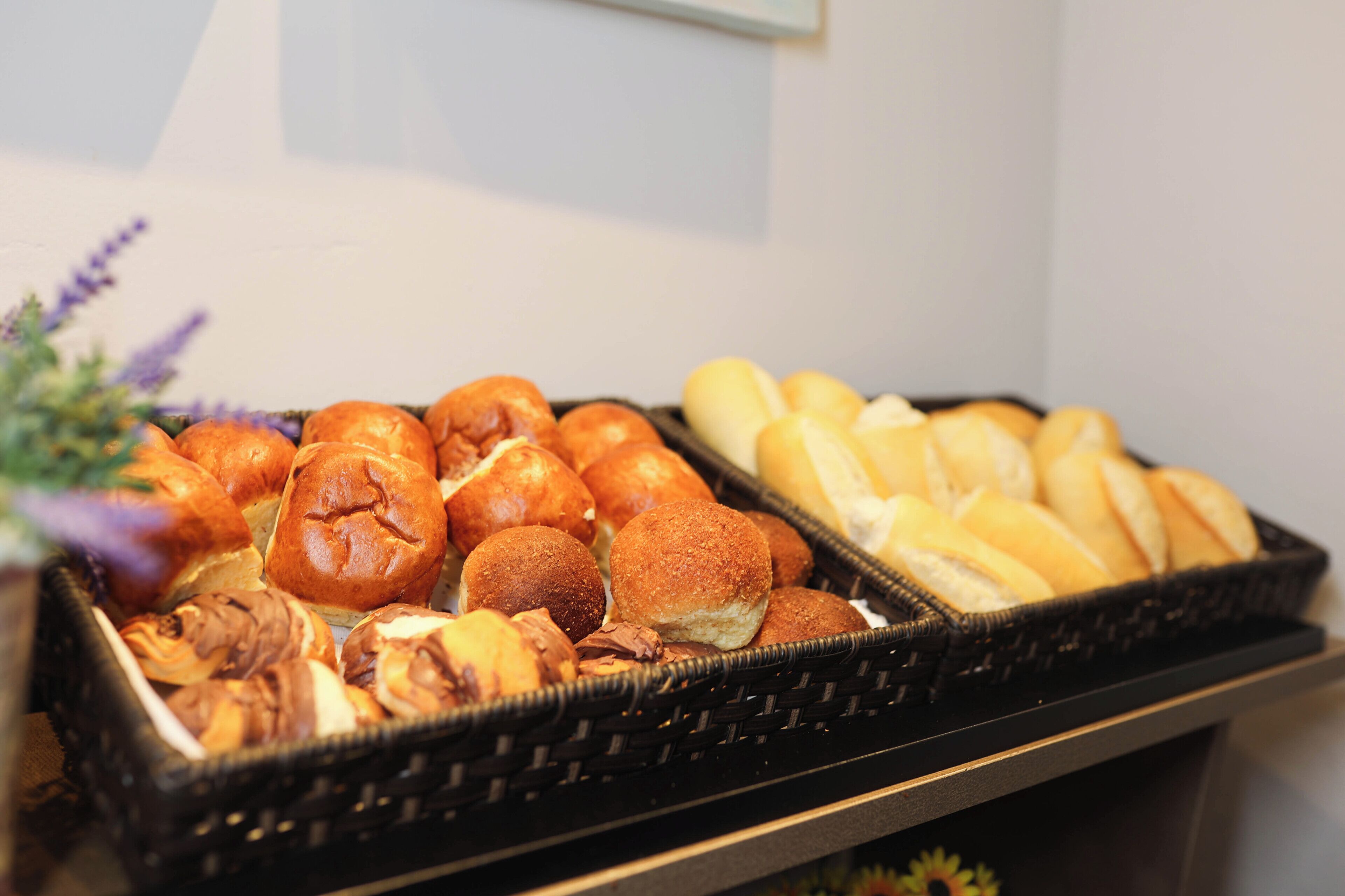 Een schaal met diverse gebakjes, waaronder broodjes en bollen.