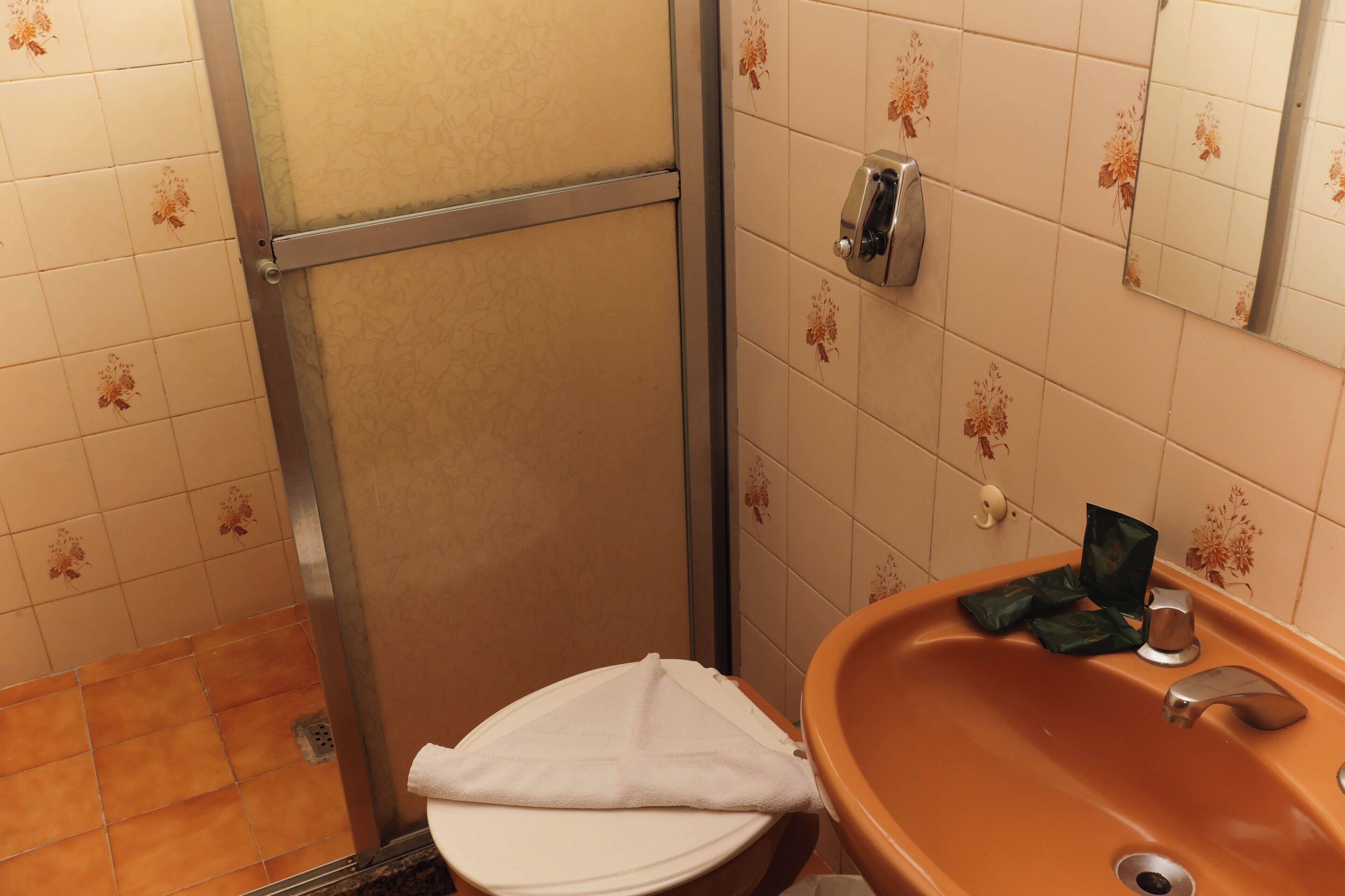 A bathroom with a toilet, a sink, and a shower stall.