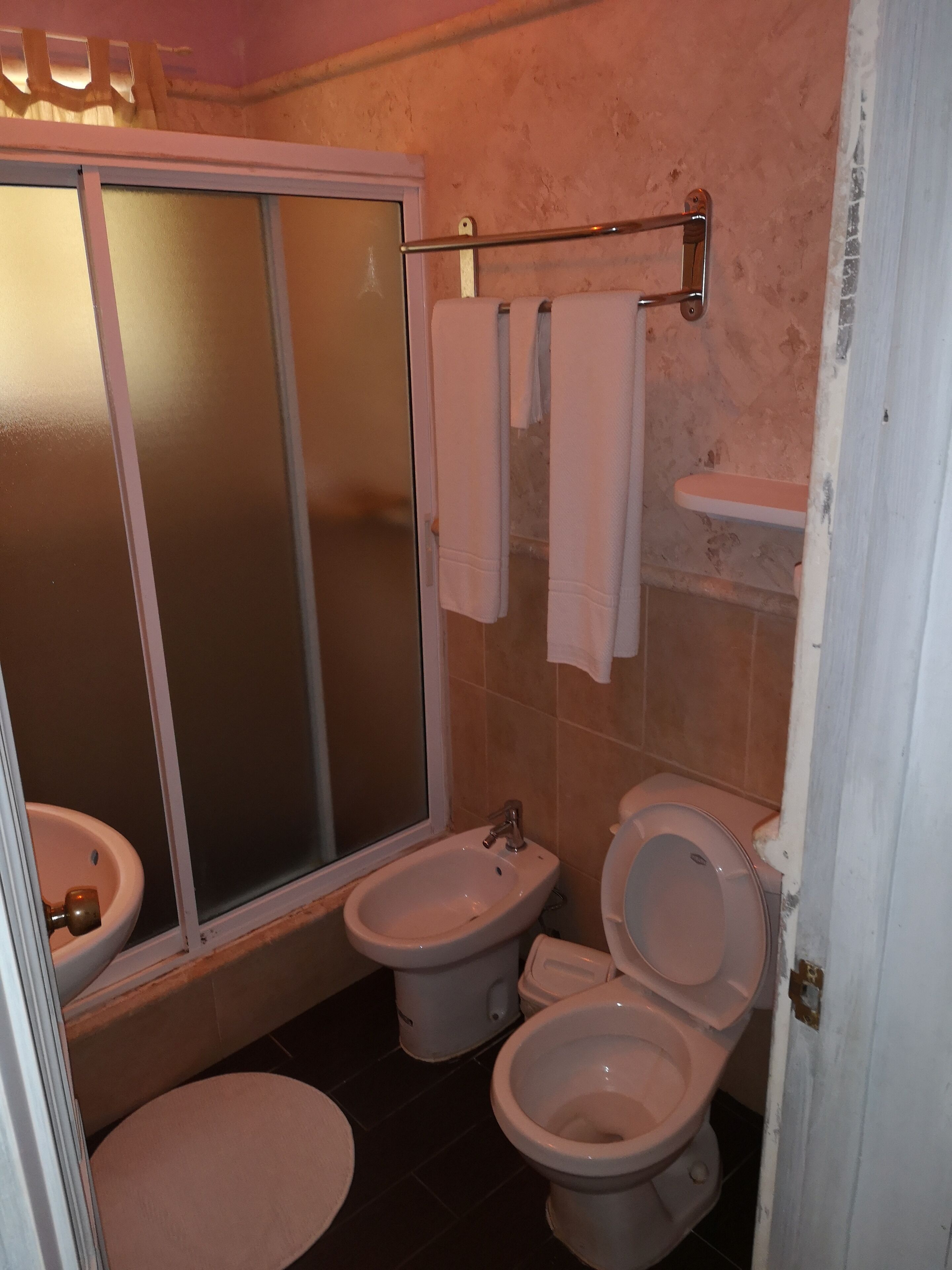 Un baño con ducha, bidé, inodoro y lavabo.