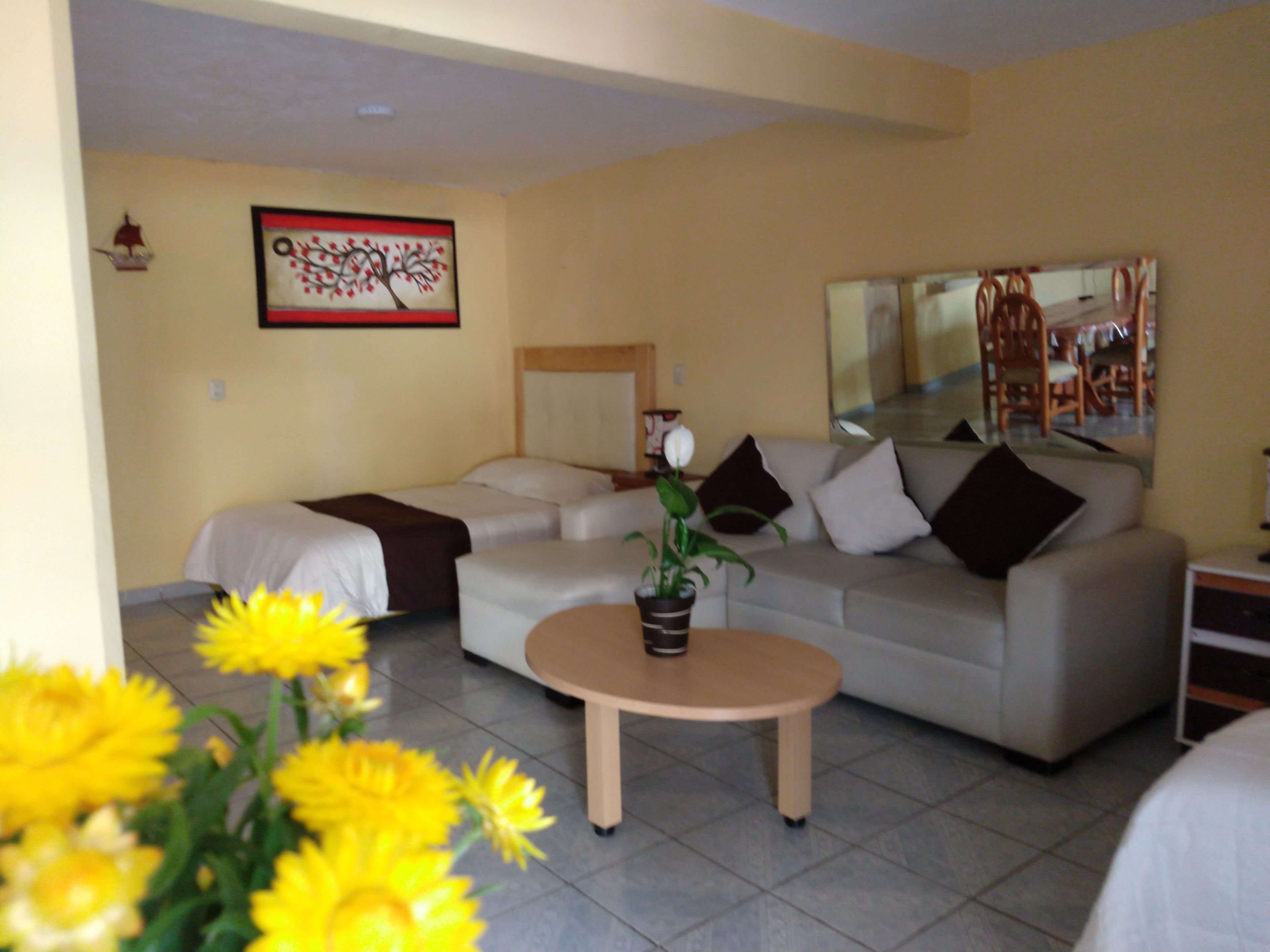 A living room with a sofa, a coffee table, and a painting on the wall.