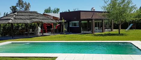 En säsongsöppen utomhuspool, parasoller och solstolar