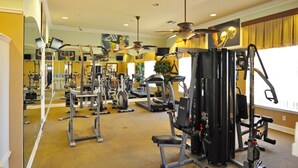 Una palestra con diverse attrezzature per esercizi, tra cui tapis roulant e macchinari per pesi, disposte in un ambiente ampio.