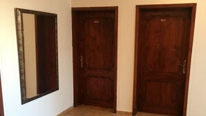 A hallway with three wooden doors, numbered 302, 301, and 303, leading to individual rooms. - Apartments & Rooms Rozana (Ulcinj)