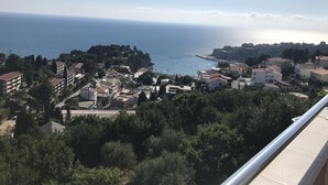 A coastal town with buildings, trees, and a clear view of the sea. - Apartments & Rooms Rozana (Ulcinj)