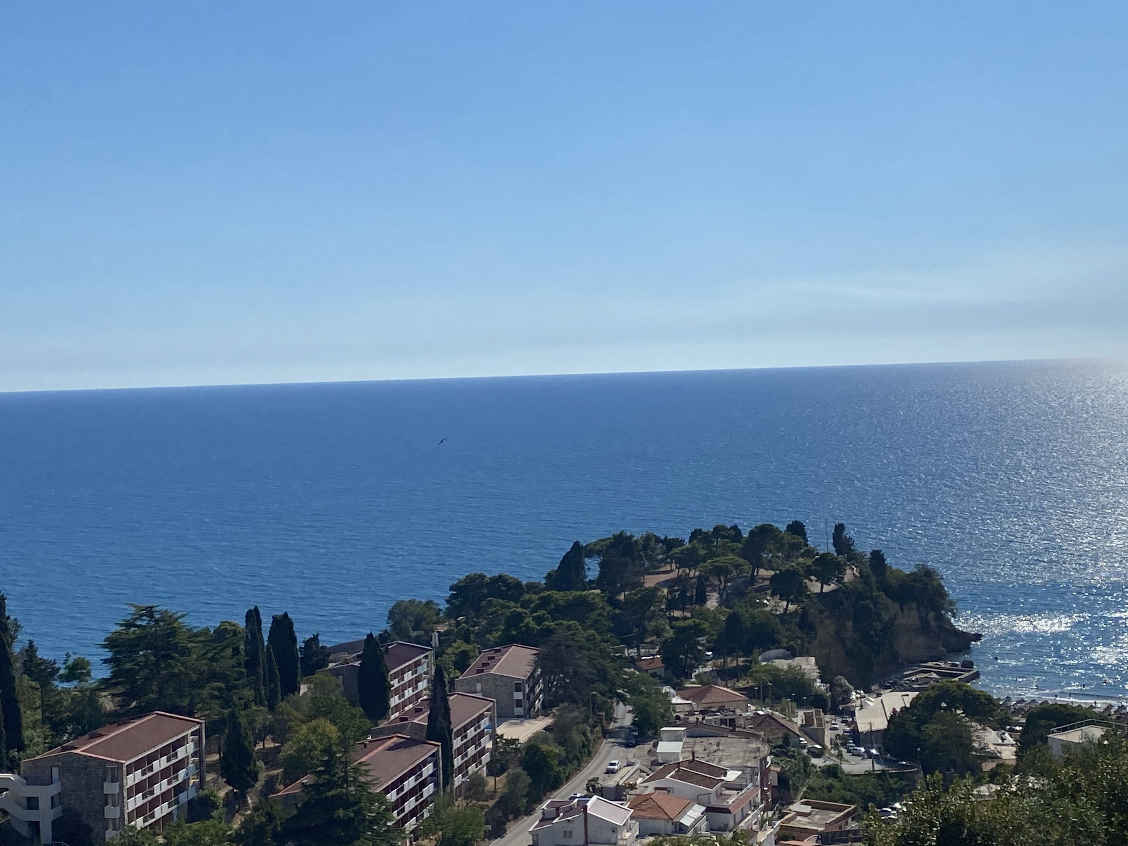 A coastal town with buildings along the cliffside, overlooking the sea.