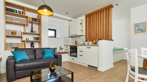 A modern living room with a sofa, coffee table, and bookshelf.