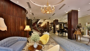 A luxurious lobby with a grand staircase, plush seating, and a grand piano. - Dong Duong Hotel (Da Nang)