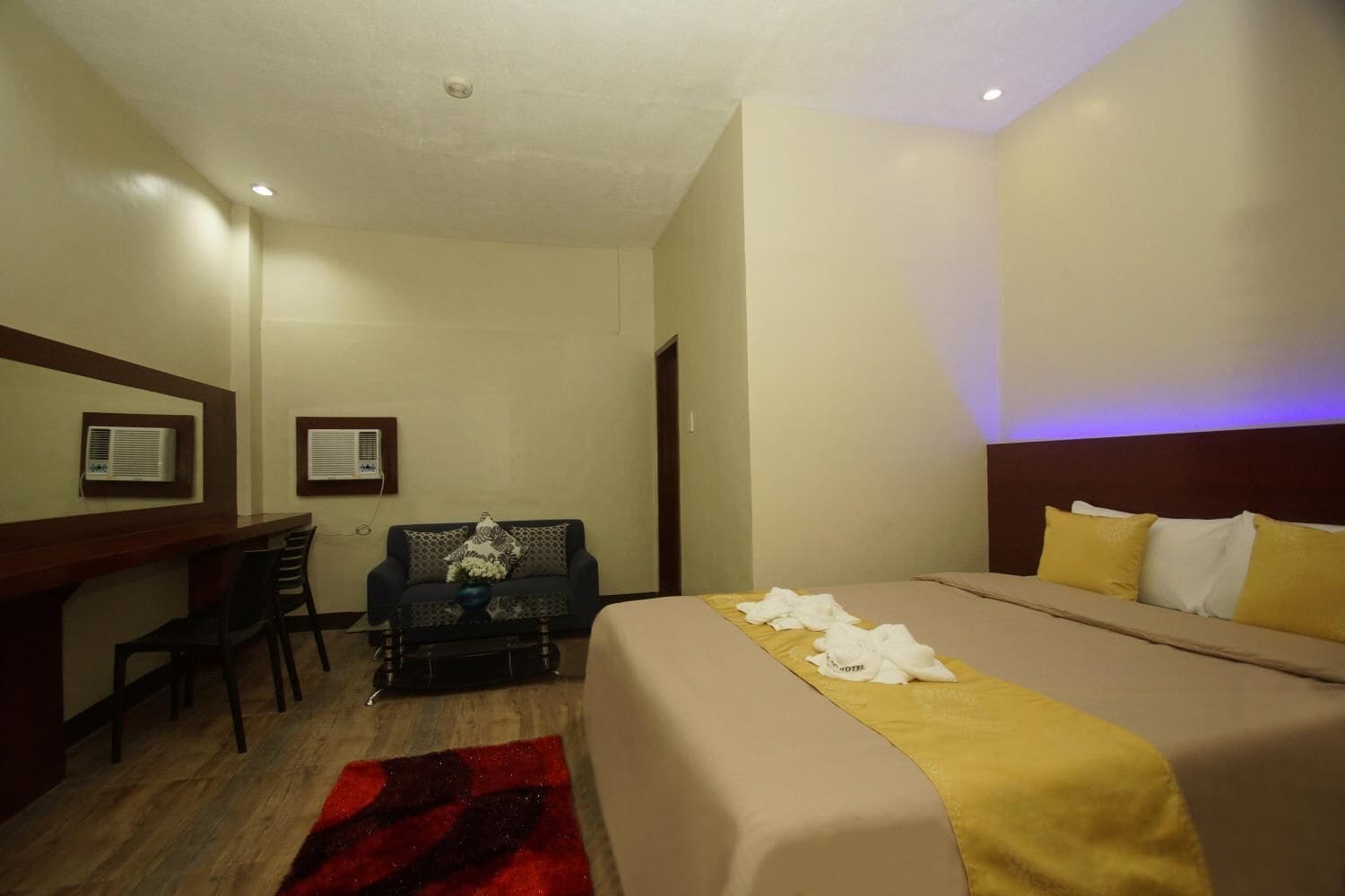 Ein Hotelzimmer mit Bett, Schreibtisch und einer Couch.