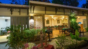 A restaurant with outdoor seating, stone walls, and indoor dining area. - RATA  Boutique (Siem Reap)