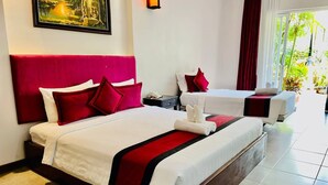 A hotel room with a large bed, a smaller bed, and a sofa. There is a painting on the wall and a window with curtains. - RATA  Boutique (Siem Reap)