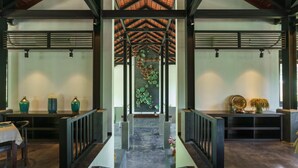 A spacious lobby with a high ceiling, a central decorative wall, and a modern staircase. - Aravinda Resort (Nam Hoa Lu)