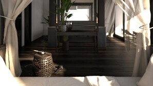 A room with a bed, a ceiling fan, a window, and a small table with plants. - Aravinda Resort (Nam Hoa Lu)