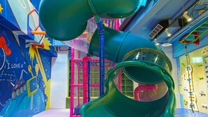 Een speelruimte voor kinderen met meerdere glijbanen en een bällebad.