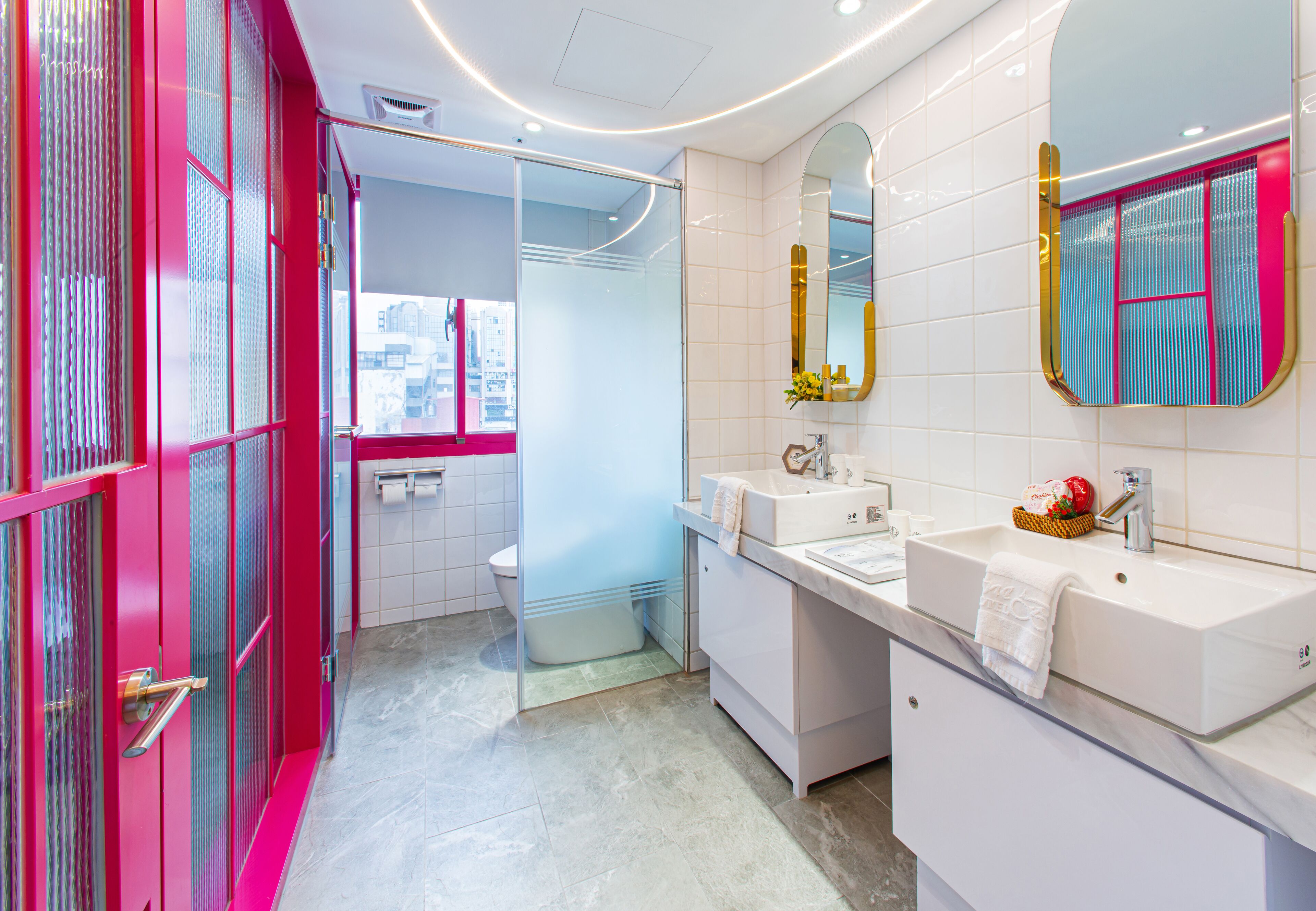 A modern bathroom with a large mirror, two sinks, and a glass shower enclosure.