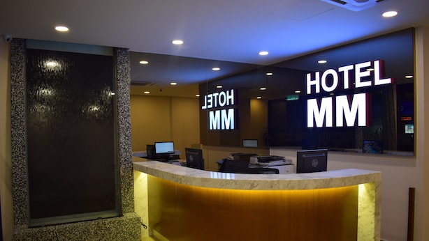 A hotel reception desk with a modern design, featuring a marble counter and a large illuminated sign that reads "HOTEL MM". - MM Hotel at Sunway (Petaling Jaya)