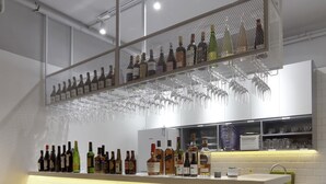 A bar area with a checkered floor, stools, a bar counter with bottles, glasses, and a small refrigerator. - The Moment We Met (Changzhou)
