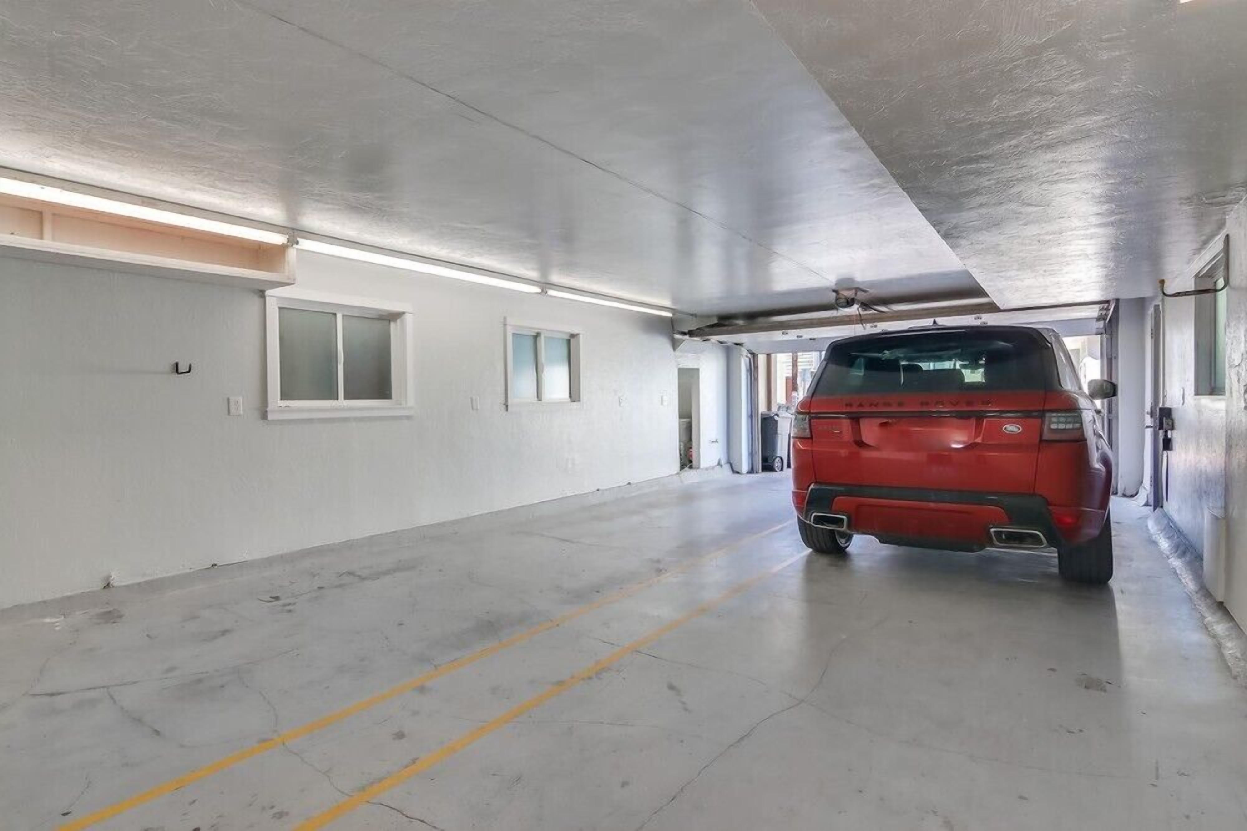 A parking garage with a red vehicle parked in the center.