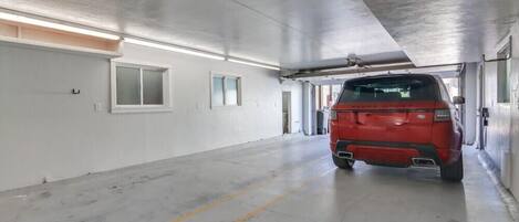 A parking garage with a red vehicle parked in the center.