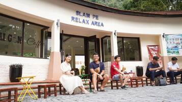 Et siddeområde uden for en bygning med et skilt, der står 'SLAM PE RELAX AREA'.