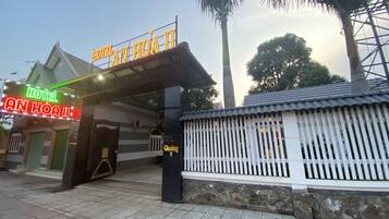 The entrance to Hotel An Hoa II with a traditional architectural style, a gated entrance, and a clear sky.