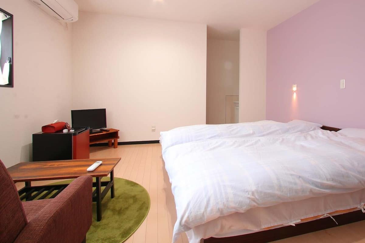 Een hotelkamer met een groot bed, een bureau met een televisie en een stoel.