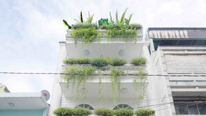 Un immeuble doté de nombreux balcons ornés de plantes et de verdure.