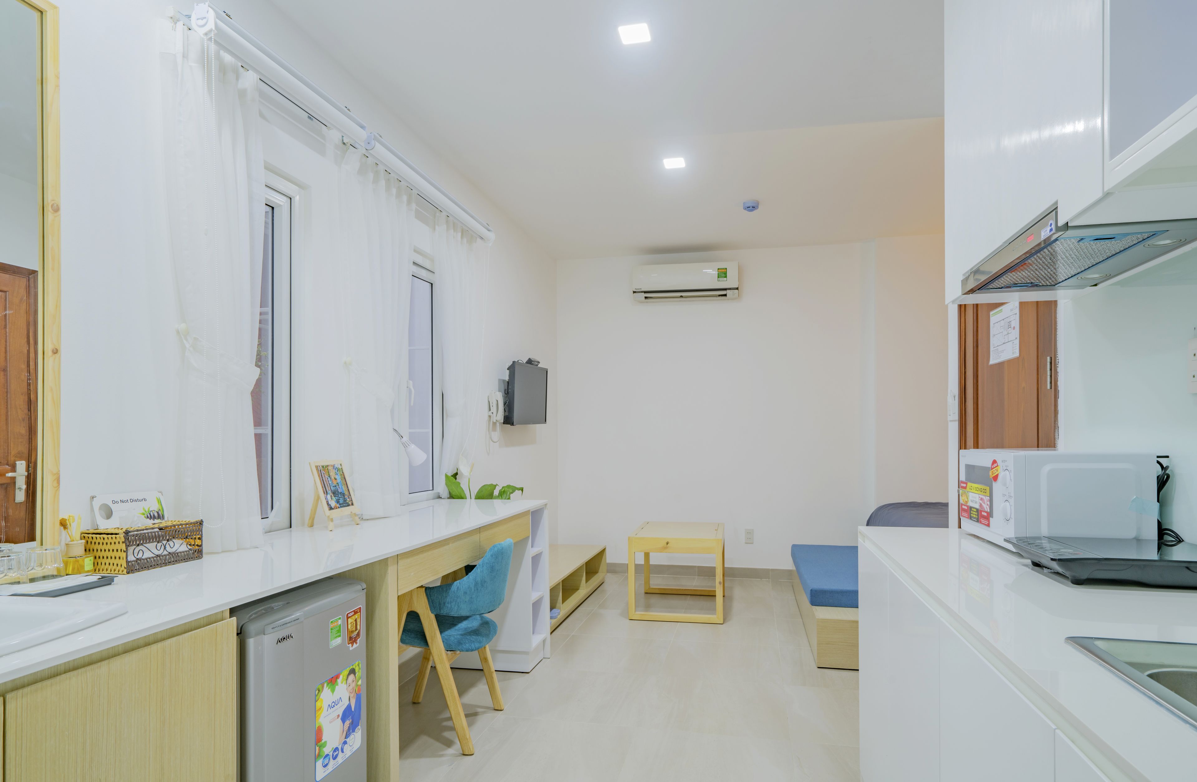 A compact kitchen with a refrigerator, microwave, and a small dining area.