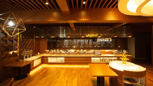 A modern interior with wooden flooring, a central bar area with multiple counters, and a geometric light fixture. - Dragon King 1 Hotel Da Lat (Xuan Huong - Da Lat)