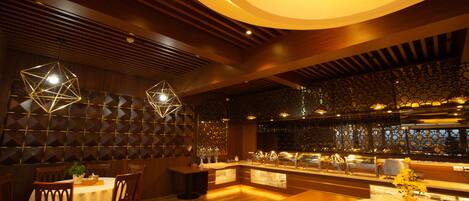 A restaurant with wooden flooring, a bar area, and geometric light fixtures.