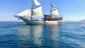 A sailing boat with multiple sails, a cabin, and a deck area. - Perjuangan Boat 2 (Labuan Bajo)